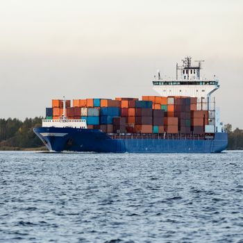 Blue container ship moving to Baltic sea. Riga, Latvia