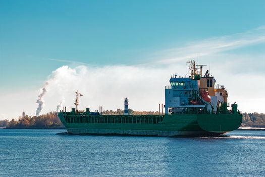 Green cargo ship entering a port of Riga, Europe