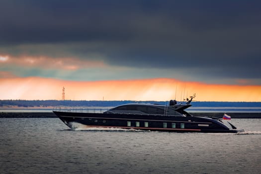 Black elite speed motor boat moving fast from Baltic sea