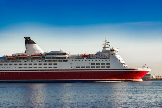 Red cruise liner. Passenger ferry ship sailing in still water