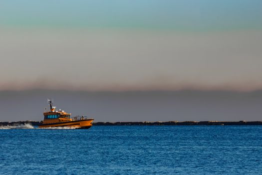 Orange pilot ship sailing from the Baltic sea in Latvia