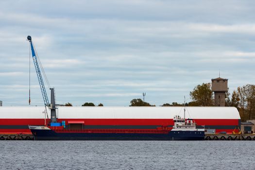 Blue cargo ship loading in the port of Riga, Europe