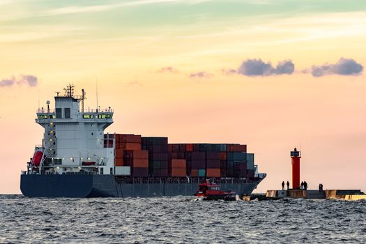 Blue container ship leaving Riga and entering Baltic sea