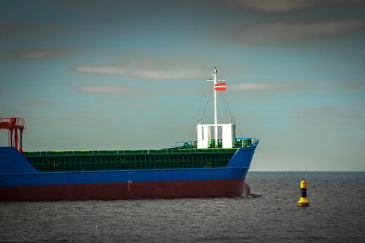 Blue cargo ship's bow leaving the port of Riga