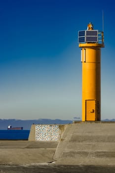 Yellow lighthouse on breakwater dam in Riga, Europe