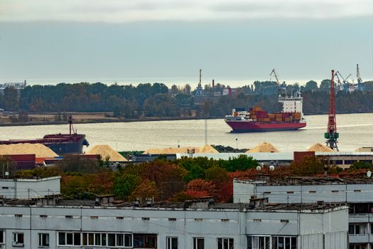 Red container ship entering port of Riga, Latvia