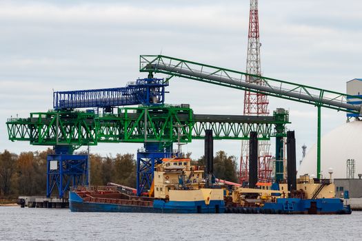 Blue cargo ship loading in the port of Riga, Europe