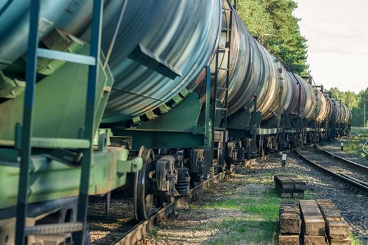 Tank wagons with oil. Freight train in forest