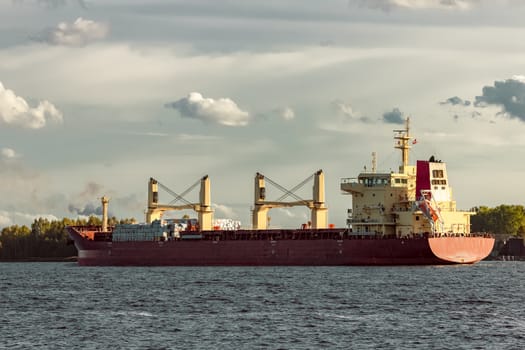 Red cargo ship sailing to the port of Riga