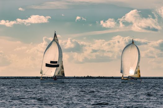 Sailboat regatta on Daugava river. Two yachts sailing in Riga