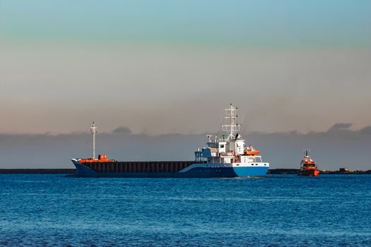 Blue cargo ship leaving Riga and entering Baltic sea