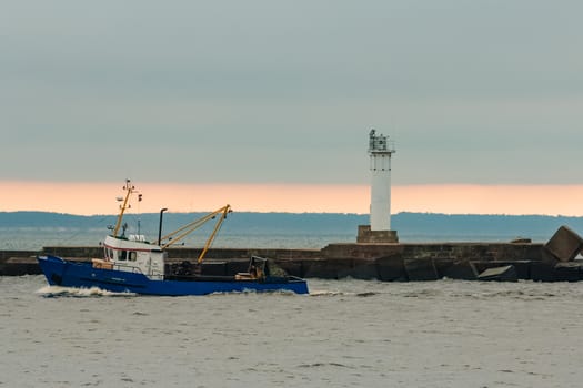 Blue fishing ship sailing in stll water