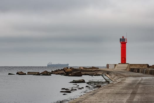 Breakwater dam with red lighthouse in Riga, Europe
