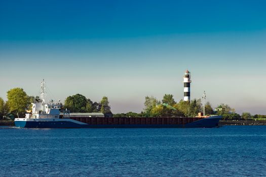 Blue cargo ship leaving Riga and entering Baltic sea