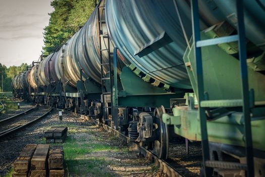 Tank wagons with oil. Freight train in forest