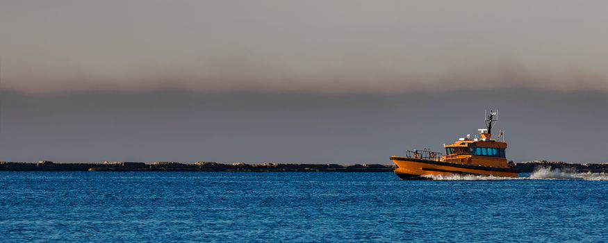 Orange pilot ship sailing from the Baltic sea in Latvia