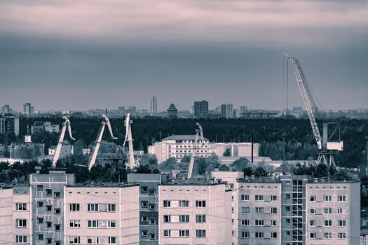 Residential area in Riga with soviet houses and cargo cranes