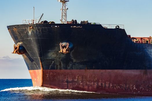 Black cargo ship's bow in still water. Riga, Europe