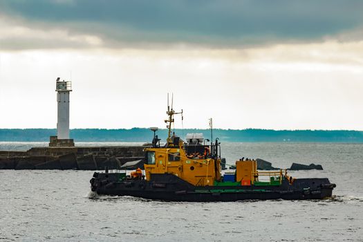 Small orange tug ship moving from the Baltic sea