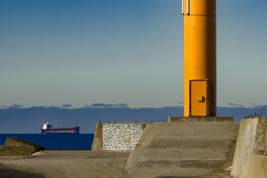 Yellow lighthouse on breakwater dam in Riga, Europe