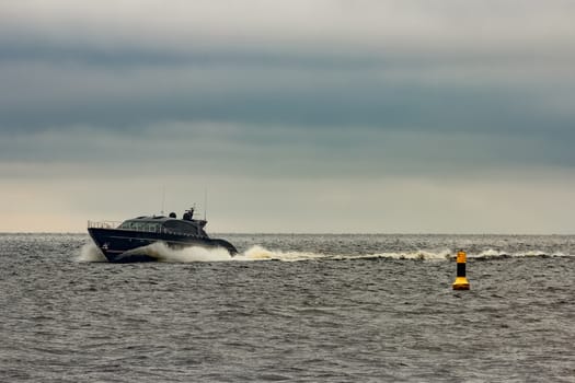 Black elite speed motor boat moving fast from Baltic sea