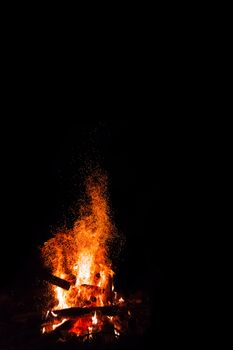 Campfire with flying sparks isolated on black background