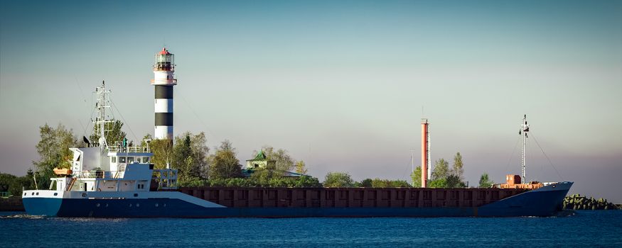 Blue cargo ship leaving Riga and entering Baltic sea