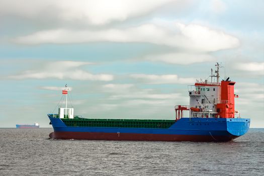 Blue cargo ship entering the Baltic sea. Riga, Europe