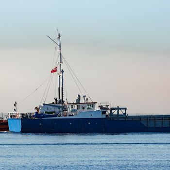 Blue cargo ship leaving Riga and entering Baltic sea