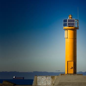 Yellow lighthouse on breakwater dam in Riga, Europe