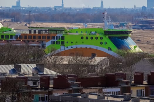 Green cruise liner. Passenger ferry sailing past the Riga city