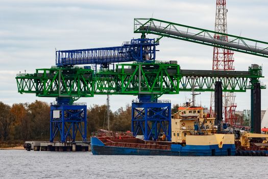 Blue cargo ship loading in the port of Riga, Europe