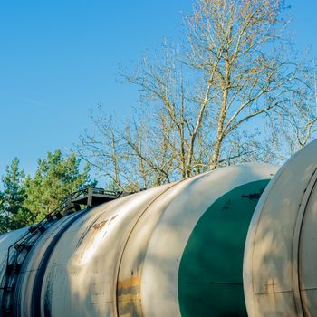 Tank wagons with oil. Freight train in forest