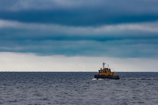 Small orange tug ship moving from the Baltic sea