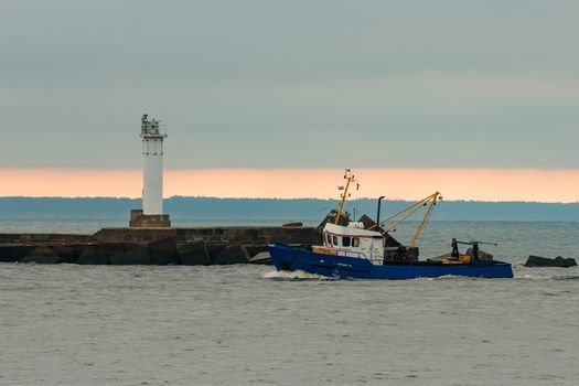 Blue fishing ship sailing in stll water