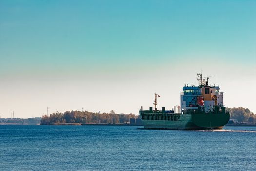 Green cargo ship entering a port of Riga, Europe