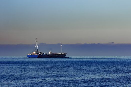 Blue cargo ship leaving Riga and entering Baltic sea