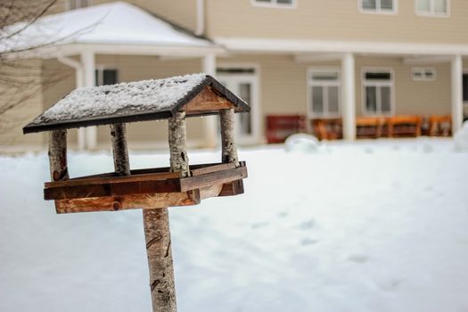 Wooden birdhouse in winter day close up