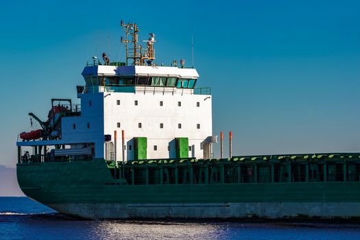 Green cargo ship's cabin in still Baltic sea water, Riga