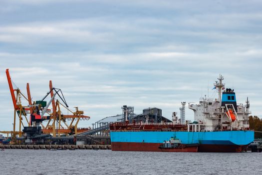 Blue cargo ship loading in the port of Riga, Europe