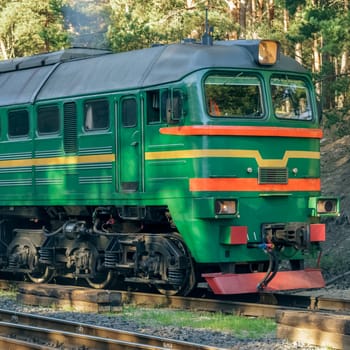 Green diesel cargo locomotive in forest