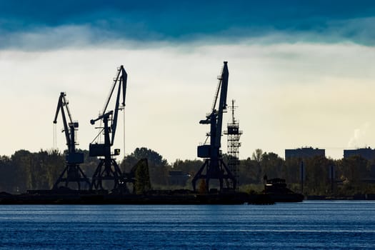 Cargo cranes silhouette in the morning, Riga