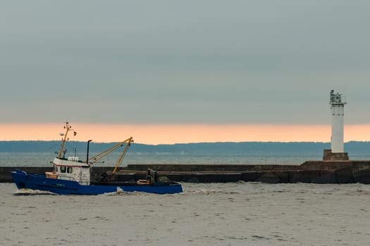 Blue fishing ship sailing in stll water