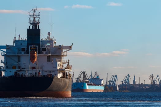 Black cargo ship entering the port of Riga, Europe