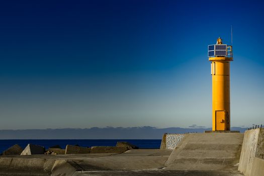 Yellow lighthouse on breakwater dam in Riga, Europe