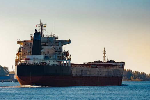 Black cargo ship entering Riga, Europe