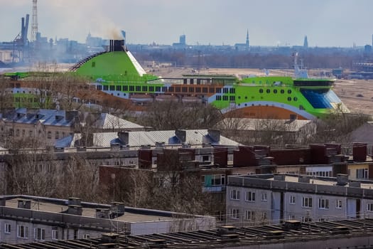 Green cruise liner. Passenger ferry sailing past the Riga city