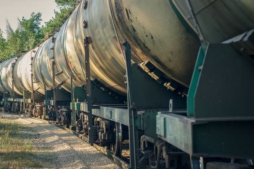 Tank wagons with oil. Freight train in forest