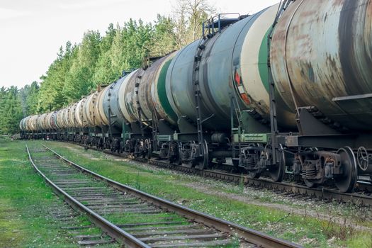 Tank wagons with oil. Freight train in forest