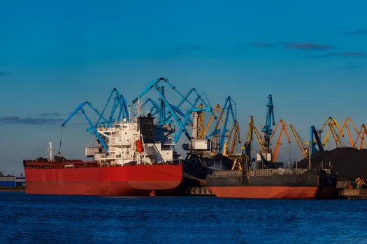 Red cargo ship loading in the port of Riga, Europe